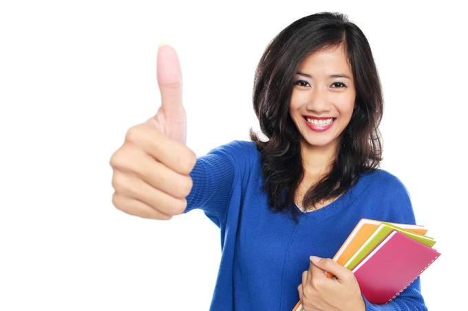 Young Female Student With Books Showing Thumb Up